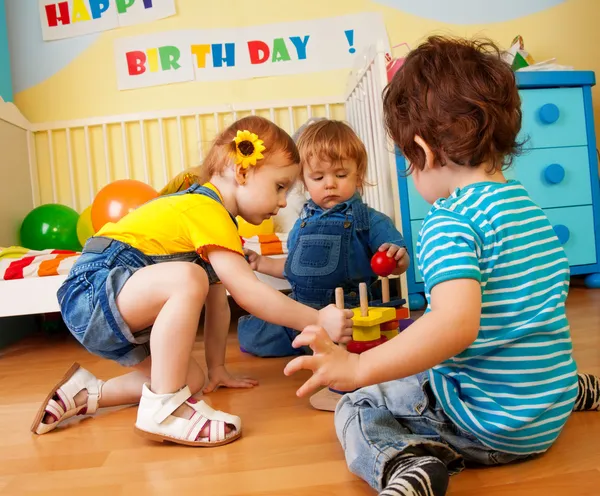 Zwei Jungen und Mädchen spielen mit Spielzeug Pyramide Puzzle — Stockfoto