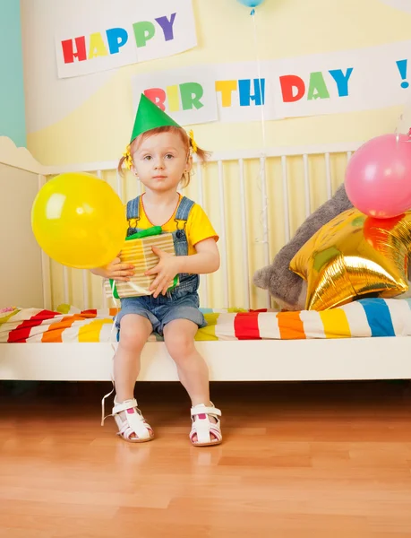 Kleines Mädchen mit Geschenk und Luftballon — Stockfoto