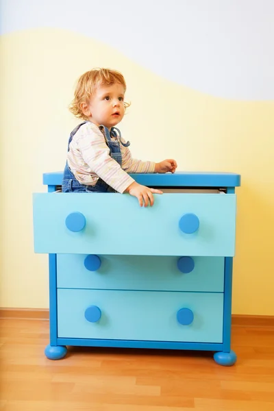 Criança sentada dentro da caixa do armário — Fotografia de Stock