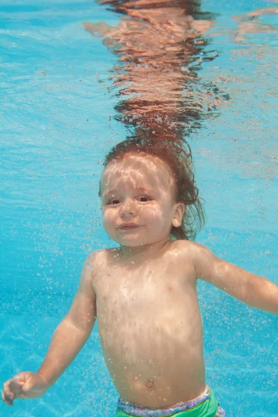 Happy toddler kid diving under water