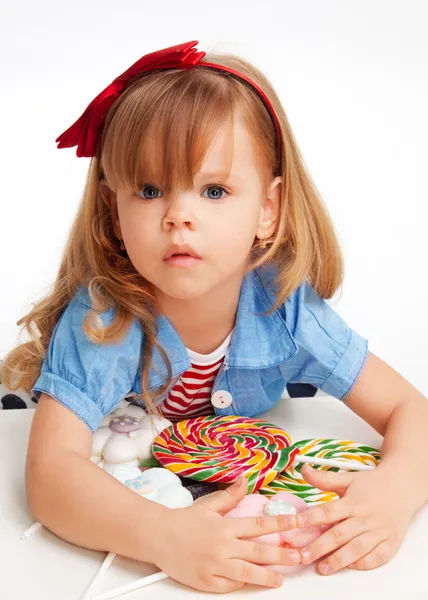 Menina gananciosa com pilha de doces — Fotografia de Stock