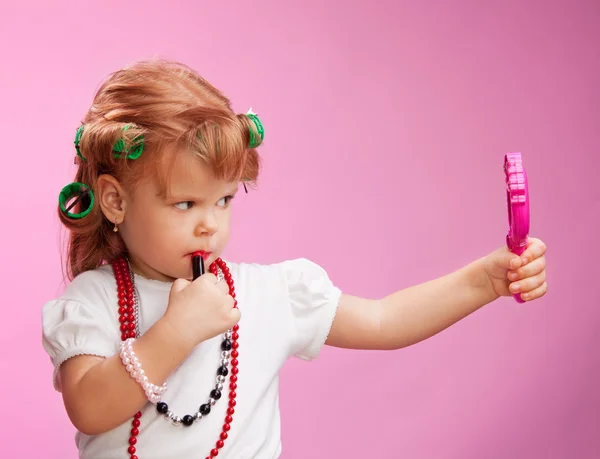 Little girl playing with mothers makeup — Stock Photo, Image