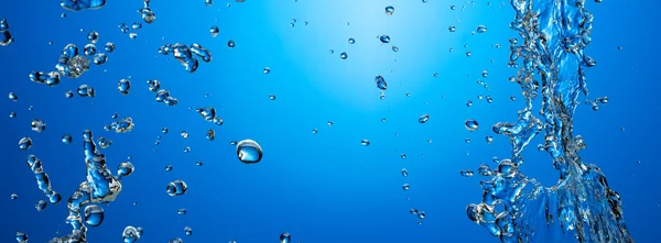 Vody bubliny v modré vodě — Stock fotografie