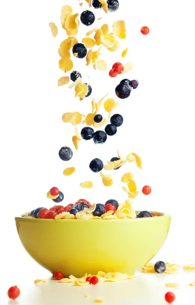 Flying to the bowl corn flakes with berries — Stock Photo, Image