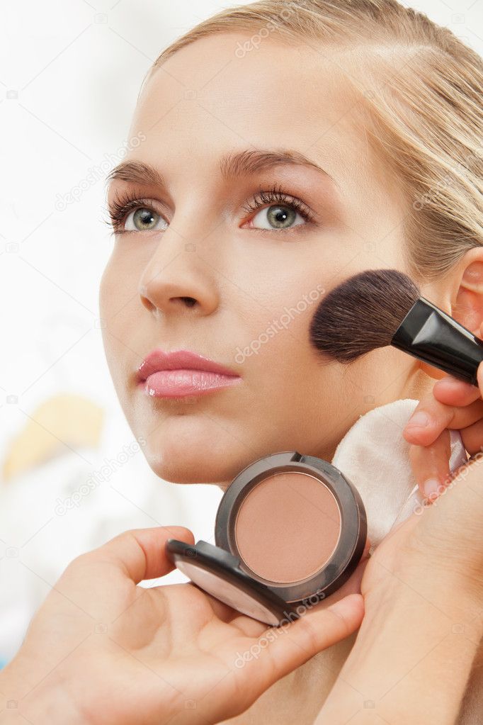 Makeup artist apply blush on cheeks