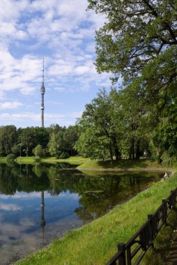 Lake in park with a kind on television tower Ostankino in Russia clipart