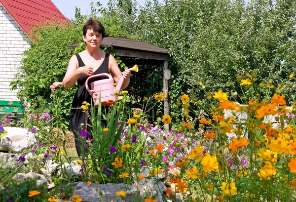 Frau gießt Blumen auf Sommerresidenz — Stockfoto