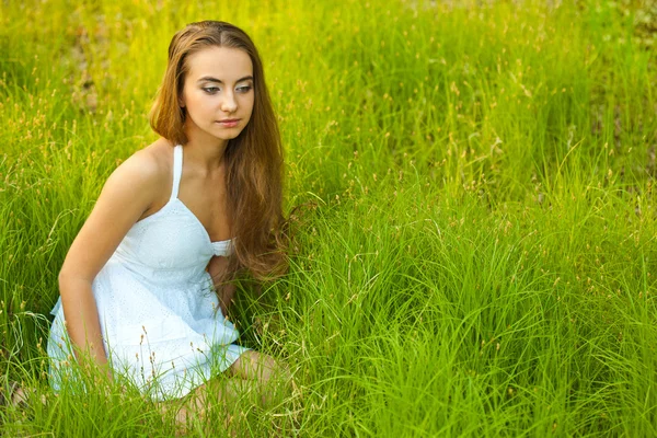 Красивая женщина, сидящая в траве — стоковое фото