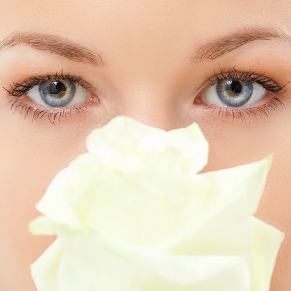 Closeup γυναίκα μάτια με το ροδαλό λουλούδι — Φωτογραφία Αρχείου