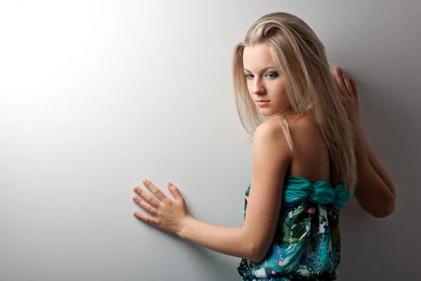 Blond kvinna poserar nära vägg — Stockfoto