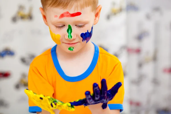 Niño mirando a sus manos pintadas — Foto de Stock