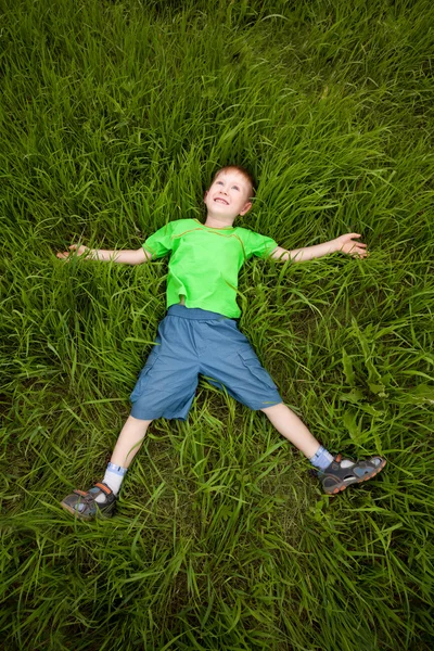Маленький мальчик лежит на траве — стоковое фото