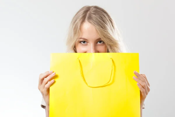 Blonda kvinnan bakom gul shopping väska — Stockfoto