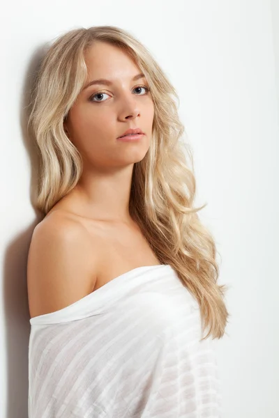 Beautiful blonde woman near white wall — Zdjęcie stockowe