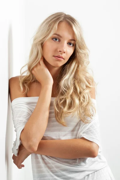 Красивая блондинка возле белой стены — стоковое фото