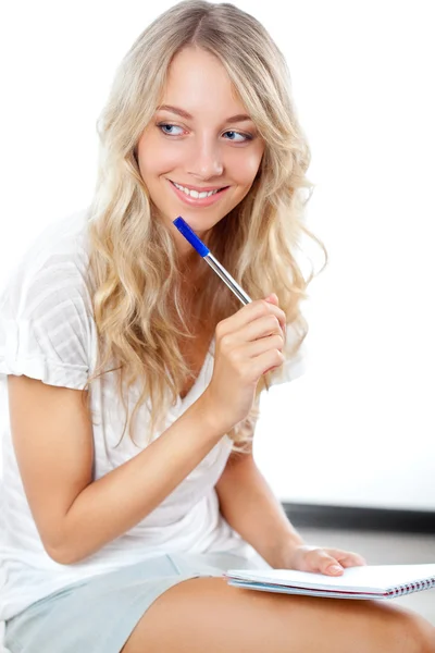 Mulher loira com caneta e bloco de notas Fotografia De Stock