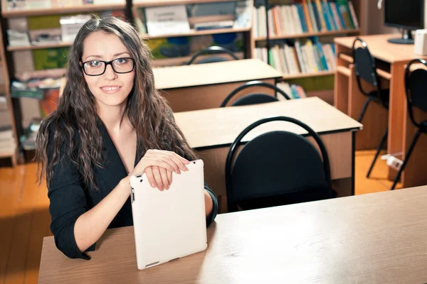 Woman sitting behind the desk at library — Stock Photo, Image