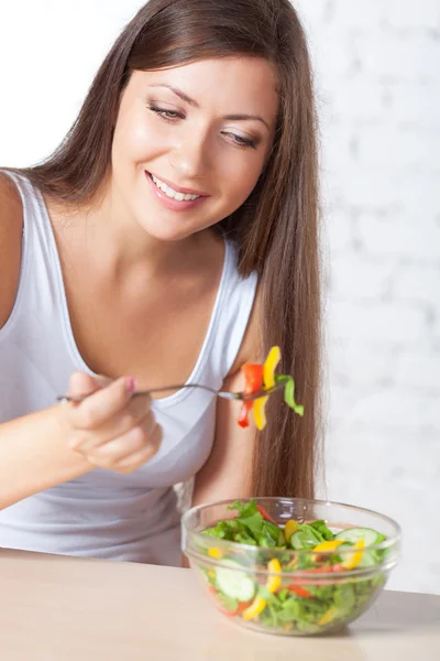 Mulher morena bonita comendo salada — Fotografia de Stock