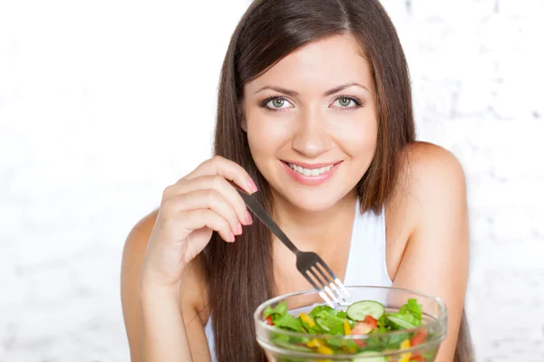 Belle femme brune mangeant de la salade — Photo