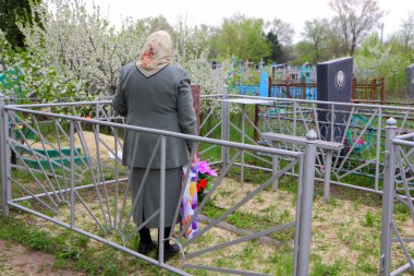yaşlı bir kadın, kocası mezarını