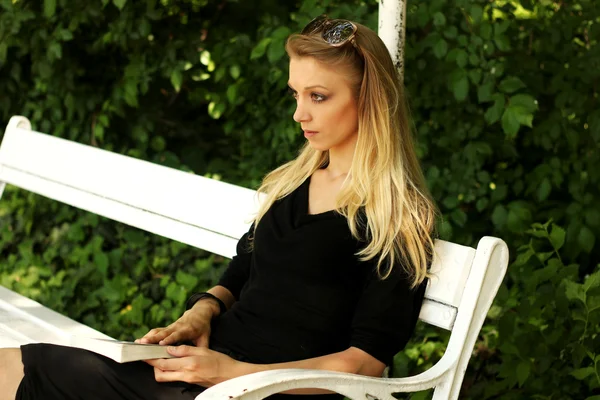 stock image Young beautiful woman reading book in the park