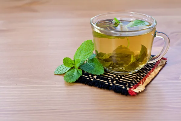 Зеленый чай с мятой на деревянном столе — стоковое фото