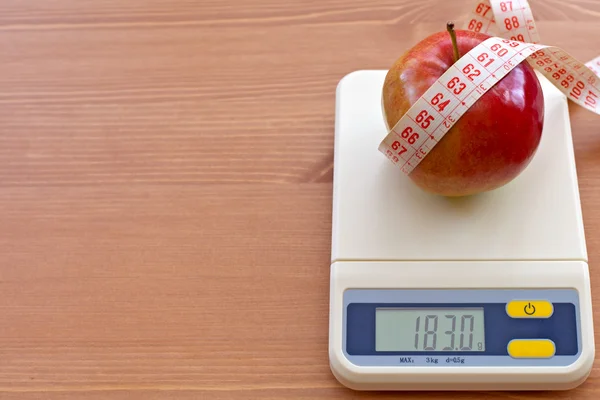 Maçã vermelha com fita métrica em escala eletrônica, conceito de dieta — Fotografia de Stock