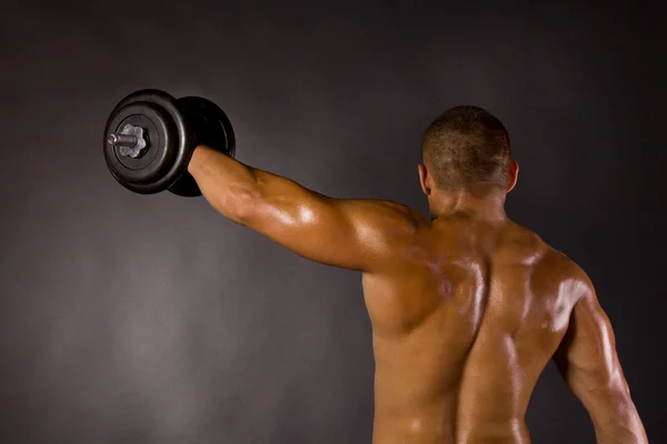 Muscoloso maschio bodybuilder dumbbell swing — Foto Stock