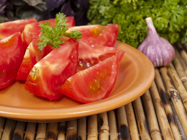Segmentos um tomate em uma chapa — Fotografia de Stock