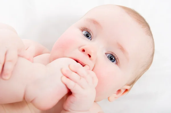 かわいい赤ちゃんの足の親指を吸う — ストック写真