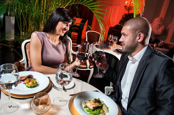 レストランでは赤ワインのガラスを持つ美しいカップル — ストック写真