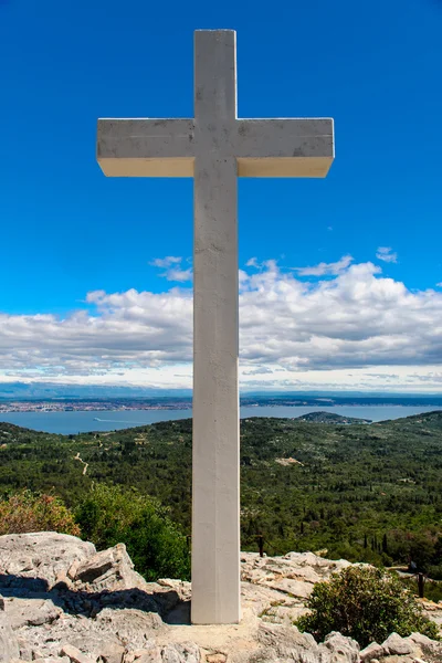 Weißes Kreuz gegen blauen Himmel und flauschige Wolken — Stockfoto