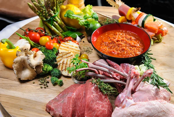 Overvloed van rauw voedsel op een houten bord — Stockfoto