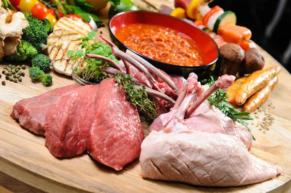 Overvloed van rauw voedsel op een houten bord — Stockfoto