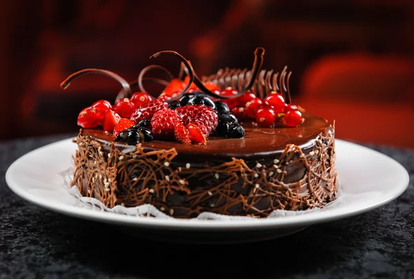 Γλυκύτατος κέικ σοκολάτας με φρέσκα μούρα σε ένα πιάτο Εικόνα Αρχείου