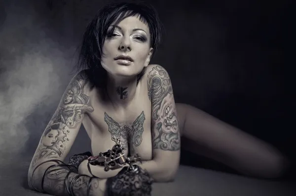 Piękna kobieta z wielu tatuaże pozowanie pomieszczeniu — Zdjęcie stockowe