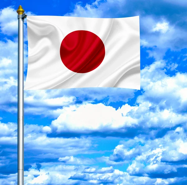 Japonsko mává vlajkou proti modré obloze — Stock fotografie