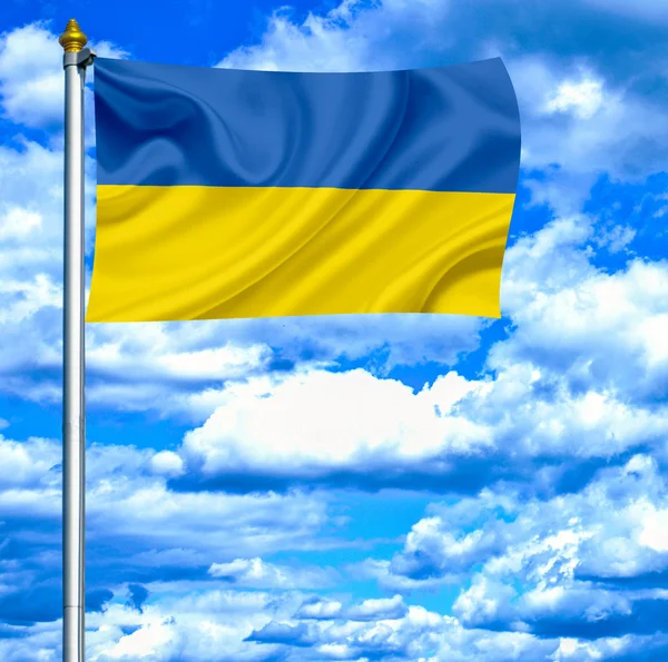Ukraina macha flagą przeciw błękitne niebo — Zdjęcie stockowe