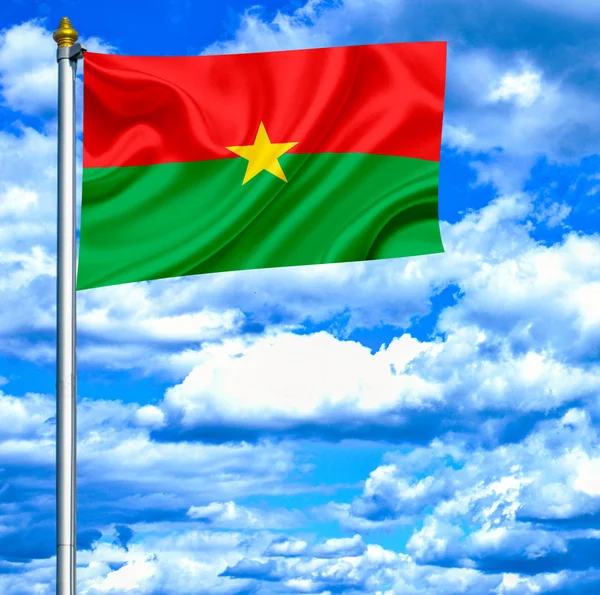 Буркина-Фасо размахивает флагом на фоне голубого неба — стоковое фото