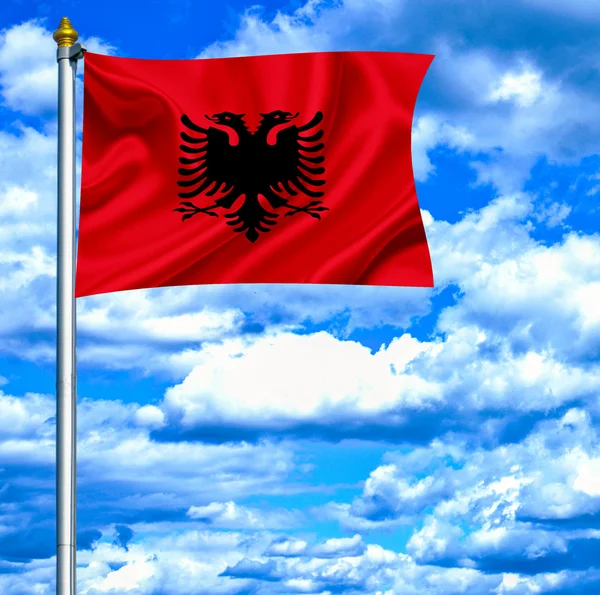 Albánie mává vlajkou proti modré obloze — Stock fotografie