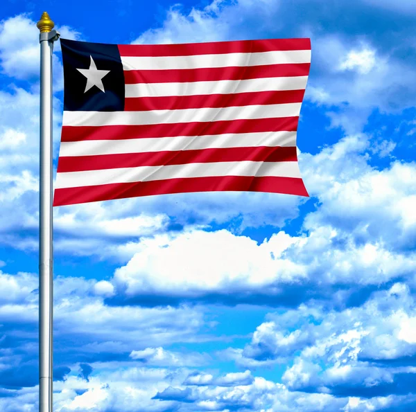 Libérie mává vlajkou proti modré obloze — Stock fotografie