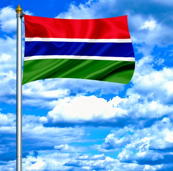 Гамбії, розмахуючи прапором проти синього неба — стокове фото
