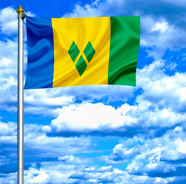 Saint Vincent ja Grenadiinit heiluttavat lippua sinistä taivasta vasten — kuvapankkivalokuva
