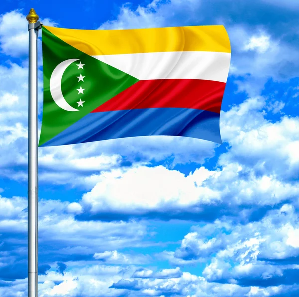 Comoren zwaaien vlag tegen blauwe hemel — Stockfoto