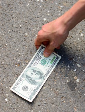 Hand picking money from street floor - Finding money on street c clipart