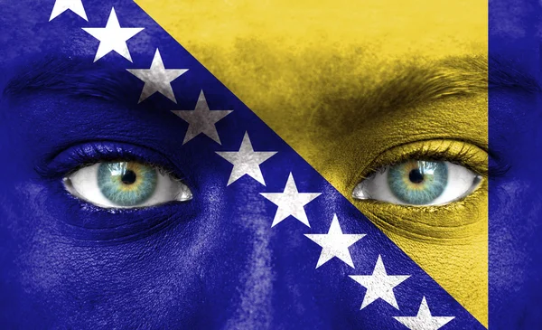 Rosto humano pintado com bandeira da Bósnia e Herzegovina — Fotografia de Stock