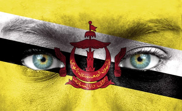 Visage humain peint avec le drapeau de Brunei — Photo