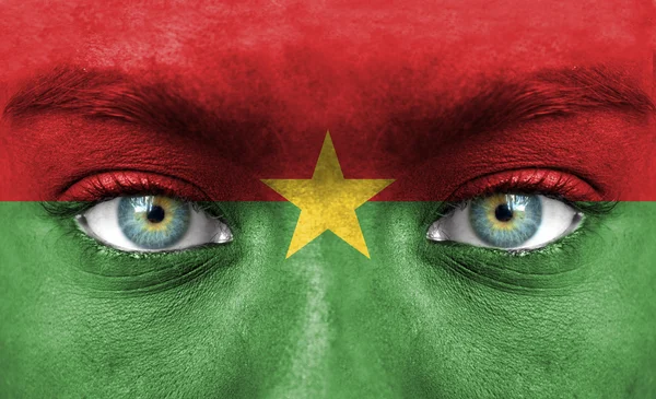 Menselijk gezicht beschilderd met vlag van burkina faso — Stockfoto