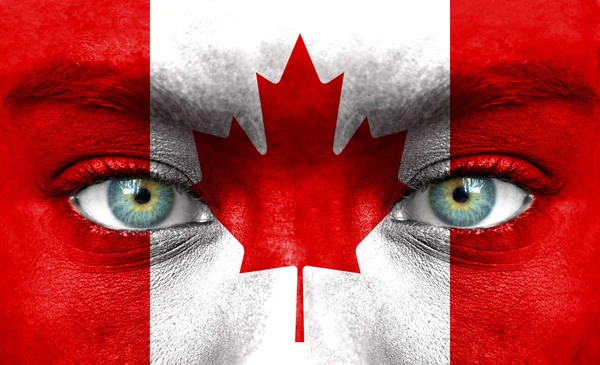 Lidská tvář s kanadská vlajka — Stock fotografie