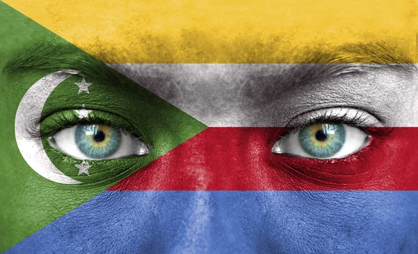 Mänskligt ansikte målade med flagga Komorerna — Stockfoto